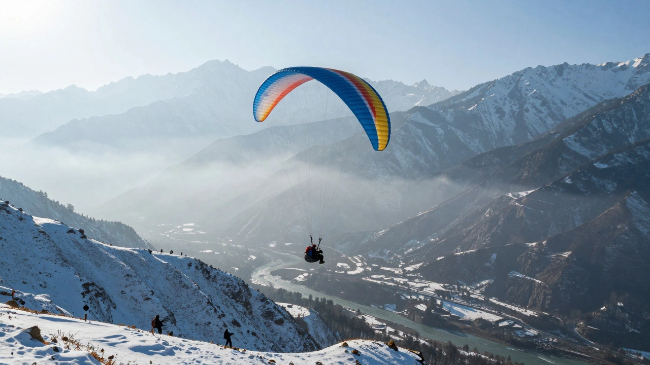 Paraglider flying over snowy Manali valley and peaks